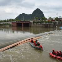 Rescuers search for missing people after two dragon boats capsized in Guilin, in southern China, on Saturday afternoon. A total of 17 people were killed after the boats capsized. Rowers onboard the two long kayak-like boats were practising for a race on the Taohua River in Guilin when the accident occurred. | AFP-JIJI