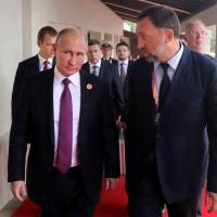 Russian President Vladimir Putin and Oleg Deripaska, who owns some of the world\'s biggest metal producers, head to a meeting of the APEC Business Advisory Council in Danang, Vietnam, on Nov. 10. | AP