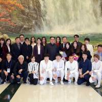 North Korean leader Kim Jong Un poses with South Korean K-pop singers in this photo released Monday. | REUTERS