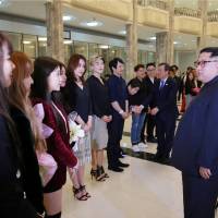 North Korean leader Kim Jong Un meets South Korean K-pop singers in this photo released Monday. | REUTERS