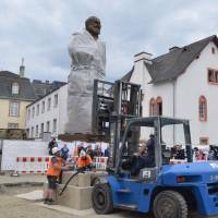 Workers install a statue of Karl Marx on Friday in Trier, Germany. | AFP-JIJI