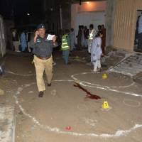 Pakistani investigators collect evidence at the shooting site outside a church in Quetta on Sunday. Two Christians were killed in the drive-by shooting outside a church in southwestern Pakistan, the second such attack on the minority community in the area this month. | AFP-JIJI