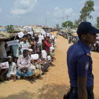 Rohingya refugees holding placards await the arrival of a U.N. Security Council team at the Kutupalong Rohingya refugee camp in Kutupalong, Bangladesh, Sunday. The U.N. Security Council team visiting Bangladesh promised Sunday to work hard to resolve the crisis involving hundreds of thousands of Rohingya Muslims who have fled to the country to escape military-led violence in Myanmar. | AP