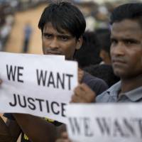 Rohingya refugees holding placards await the arrival of a U.N. Security Council team at the Kutupalong Rohingya refugee camp in Kutupalong, Bangladesh, Sunday. | AP