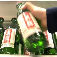 A sales clerk arranges soju liquor bottles at a store in Seoul. South Korea\'s Ministry of Food and Drug Safety said Tuesday that mixing wasps and the alcoholic beverage could pose health risks for habitual drinkers after the concoction gained popularity on the internet. | BLOOMBERG