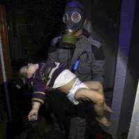 A rescue worker carries a child following an alleged chemical weapons attack in the rebel-held Syrian town of Douma, outside Damascus, on Sunday. | AP
