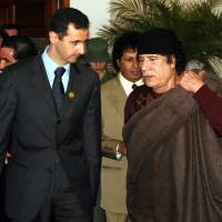 Syrian President Bashar Assad (left) talks to Libyan leader Moammar Gadhafi prior the 17th League of Arab States\' summit in Algiers in March 2005. | AP