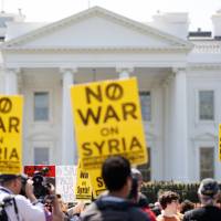 Protesters with the Answer Coalition gather in front of the White House on Pennsylvania Avenue in Washington on Saturday to denounce the bombing in Syria. | AP