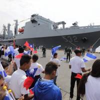 Nicaraguan students wave Taiwanese flags to welcome three Taiwanese Navy warships at Corinto port, some 150 km northwest of Managua, on Monday. | AFP-JIJI