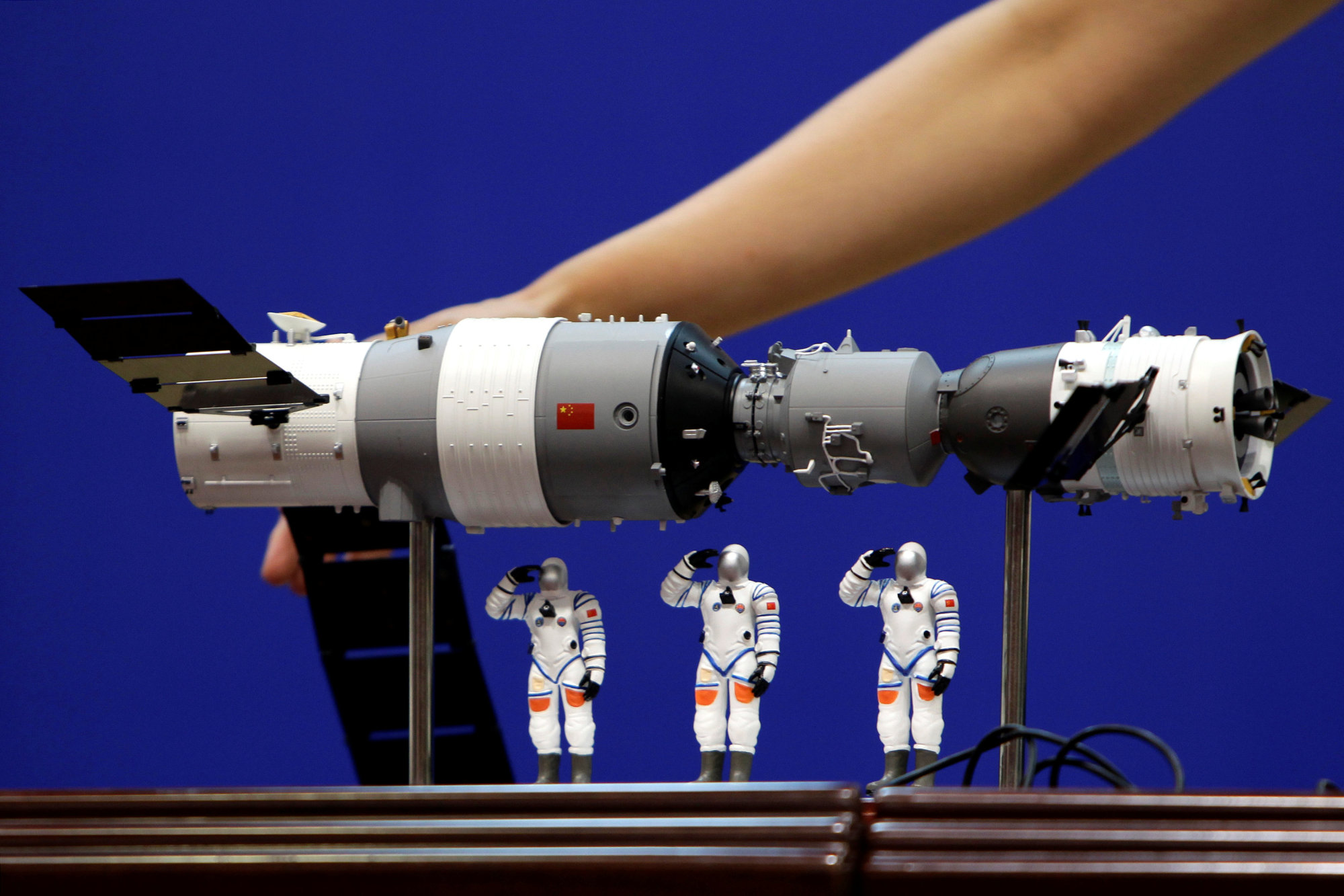 A model of the Tiangong 1 space lab module (left), the Shenzhou 9 manned spacecraft and three Chinese astronauts is displayed during a news conference at Jiuquan Satellite Launch Center in Gansu province on  June 15, 2012. | REUTERS