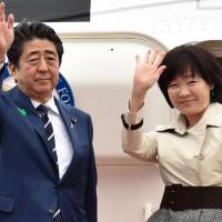 Prime Minister Shinzo Abe and his wife, Akie, wave as they prepare to depart from Tokyo\'s Haneda airport on Tuesday. | AFP-JIJI