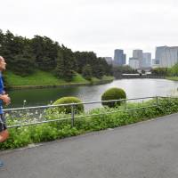 A man jogs along the Sotosakurada moat at the Imperial Palace in April. | YOSHIAKI MIURA