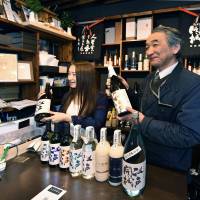 Shunichi Saito (right), president of Tokyo Port Brewery, which dates back to 1812, and his daughter, Kaede, show off the Edo Kaijo (Surrender of Edo Castle) sake brand in Minato Ward, Tokyo, on April 10. | YOSHIAKI MIURA