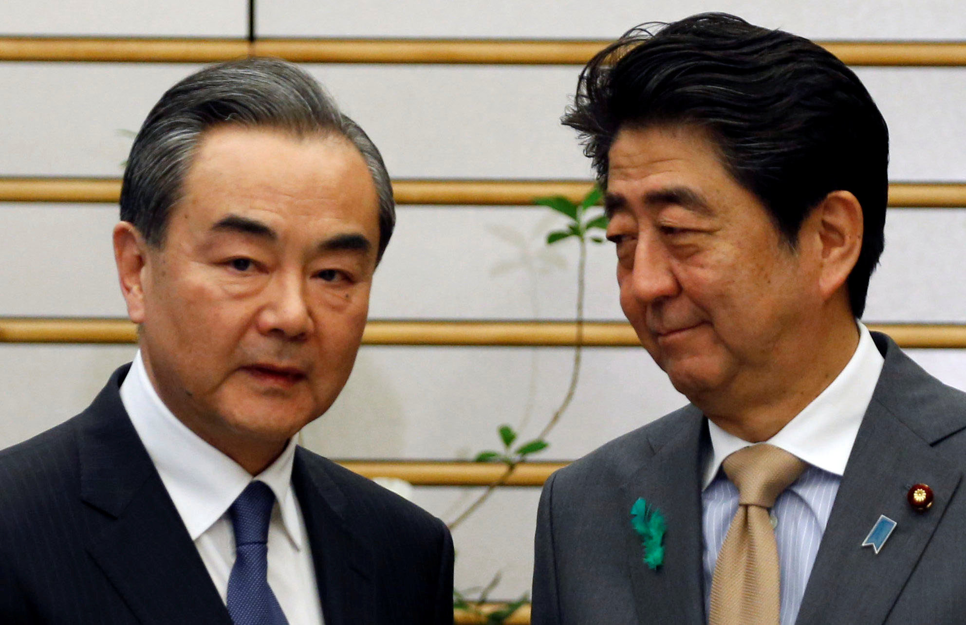 China's top diplomat, Wang Yi, meets with Prime Minister Shinzo Abe during high-level bilateral economic talks in Tokyo on Monday. | REUTERS