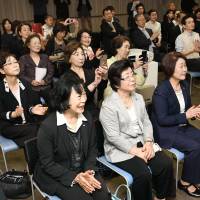 Korean residents who gathered at the Korean Cultural Center in Osaka on Friday applaud as they watch a live broadcast of North Korean leader Kim Jong Un and South Korean President Moon Jae-in shaking hands. | KYODO