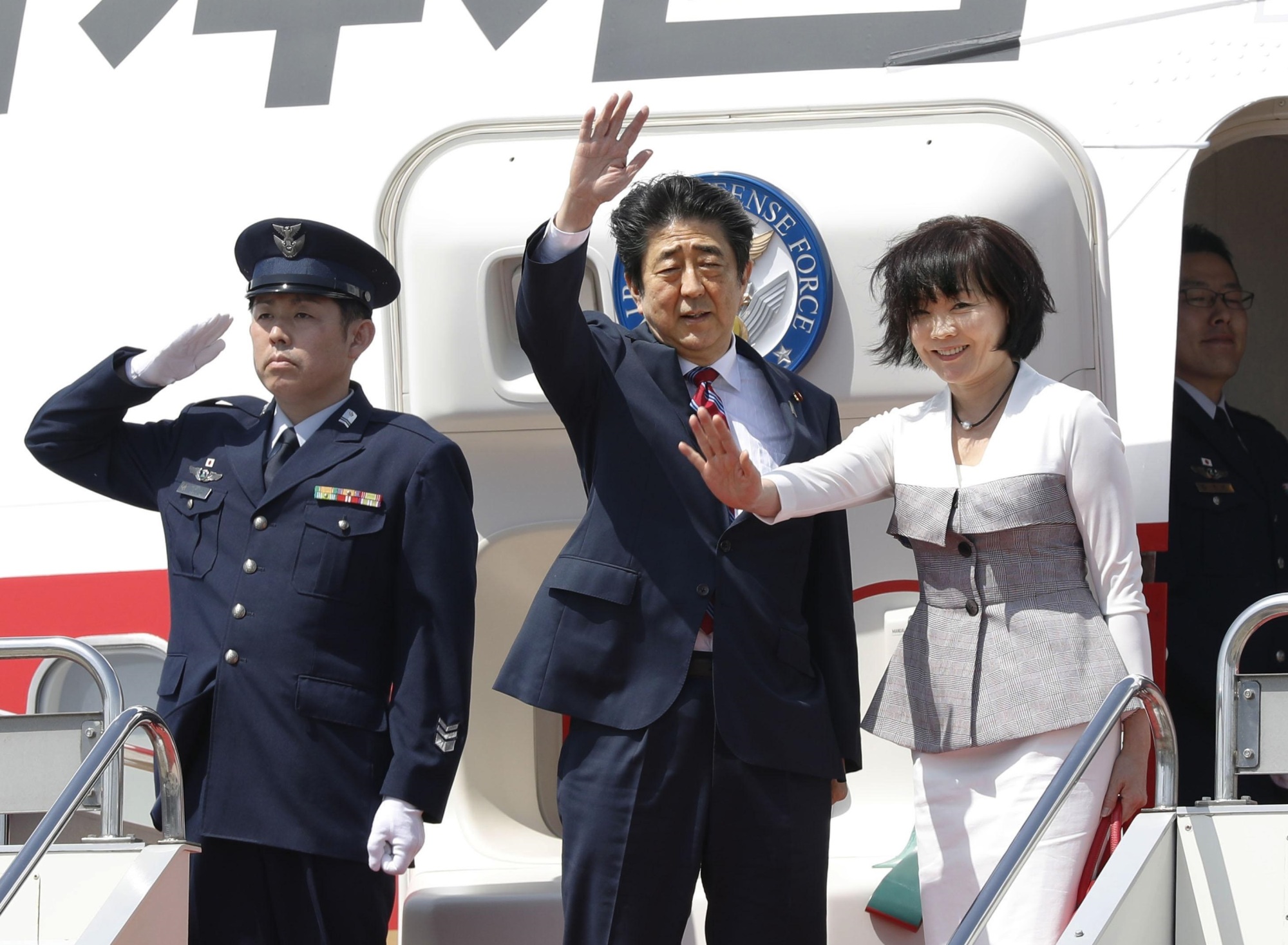 Prime Minister Shinzo Abe and his wife, Akie, wave as they leave Haneda airport for a five-day trip to the Middle East. | KYODO