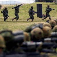 Troops from the Ground Self-Defense Force\'s Amphibious Rapid Deployment Brigade, Japan\'s first marine unit since World War II, take part in a drill at the GSDF\'s Camp Ainoura in Sasebo, Nagasaki Prefecture, on Saturday. | REUTERS