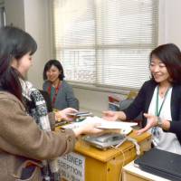 Medical interpreter Izumi Miyama talks to a patient at the Kutchan-Kosei General Hospital in the town of Kutchan near the Niseko ski resort in February. The growing influx of tourists is increasing demand for medical interpreters at resorts like Niseko. | KYODO