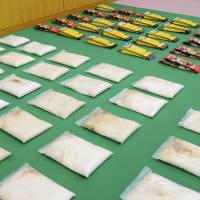 Packs of confiscated methamphetamine are shown to the media at Yokohama Customs on Monday. A couple has been arrested for attempting to smuggle the drugs, which are thought to be worth about &#165;1.8 billion. | KYODO
