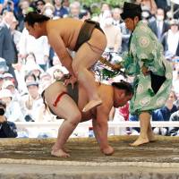 Sumo wrestlers perform during an annual sumo tournament dedicated to the Yasukuni Shrine in Tokyo on April 16. | REUTERS