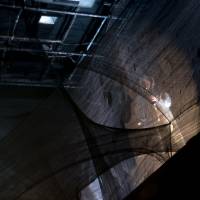 Ghost on the catwalk: A musician plays saxophone while walking a catwalk above the main performance space. | ERIK LUEBS