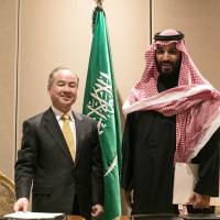 Softbank Group Corp. chairman and CEO Masayoshi Son appears with Saudi Crown Prince Mohammed bin Salman in New York on March 27 after signing a memorandum of understanding  to develop a &#36;200 billion solar power project in the kingdom. | BLOOMBERG