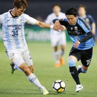 Kawasaki Frontale\'s Tatsuya Hasegawa (right) vies for the ball with an Ulsan Hyundai player during an Asian Champions League match in Kawasaki on Wednesday. The match ended in a 2-2 draw. | KYODO