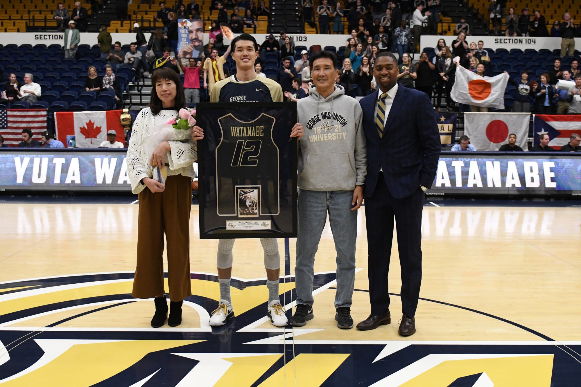 George Washington University senior star Yuta Watanabe, joined by his parents Kumi and Hideyuki and coach Maurice Joseph, was honored before the team's final home game of the 2017-18 season on Feb. 28. | GW ATHLETICS