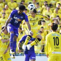 Sanfrecce forward Patric (39) and Reysol midfielder Hajime Hosogai (37) vie for a ball during the first half of their match on Sunday. | KYODO
