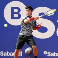 Yuichi Sugita hits a return to Guillermo Garcia-Lopez in the first round of the Barcelona Open on Monday. Sugita lost 7-6 (7-5), 7-6 (7-5). | KYODO