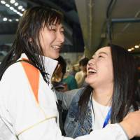 Rikako Ikee (left) embraces figure skater Wakaba Higuchi after her races at the national swimming championships on Sunday. | KYODO