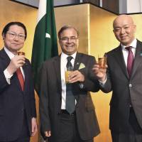 Pakistan Ambassador Asad Majeed Khan (center) joins President of Japan-Pakistan Parliamentarians Friendship League, Seishiro Eto (left), and Parliamentary Vice-Minister for Foreign Affairs Manabu Horii during a reception to celebrate the National Day of the Islamic Republic of Pakistan at Hotel New Otani Tokyo on March 22. | YOSHIAKI MIURA