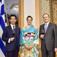 The Ambassador of Greece Loukas Karatsolis (right) and his wife, Katerina (center), welcome Parliamentary Vice-Minister for Foreign Affairs Mitsunari Okamoto during a reception to celebrate of the National Day of Greece at Hotel Okura Tokyo on March 23. | YOSHIAKI MIURA