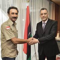 Libyan tourist Nuri Funas (left) greets Ahmed M. R. Naili, Libya\'s charge d\'affaires, at the Libyan Embassy on March 24. Funas set out from Libya to travel the world by foot in 1999, visiting such places as Scandinavia, South Africa, Senegal and now Japan. | YOSHIAKI MIURA