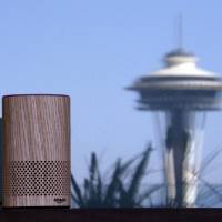 An Amazon Echo device sits on a balcony outside an Amazon office as the Space Needle is reflected in windows behind it following a program announcing several new Amazon products by the company, in Seattle last year. Amazon says an \"unlikely\" string of events prompted its Echo personal assistant device to record a Portland, Oregon, family\'s private conversation and then send the recording to an acquaintance in Seattle. | AP