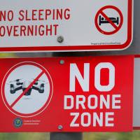 A sign at a downtown city park informs people of no overnight sleeping and no drone flying in San Diego, California, Thursday. | REUTERS