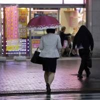 A pedestrian walks along a street in Tokyo on Monday, June 5. Gender inequality in the workplace could cost &#36;160 trillion in lost earnings globally, a World Bank study shows. | BLOOMBERG