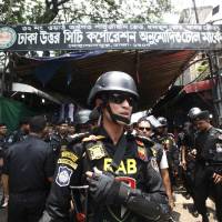 Bangladesh\'s Rapid Action Battalion (RAB) soldiers stand guard during a raid on suspected drug dealers at Mohammadpur Geneva Camp in Dhaka Saturday. More than 60 suspected drug peddlers have been killed and over 3,000 suspects detained across Bangladesh as security agencies have launched a nationwide anti-drugs crackdown since early May. | AP