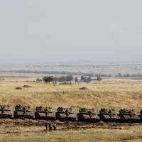 Israeli soldiers walk past tanks near the border with Syria in the Israeli-occupied Golan Heights, Israel, Friday. | REUTERS