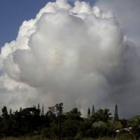 Gases rise from lava fissure 17 after it erupted early Sunday near Pahoa, Hawaii. The new fissure emitting steam and lava spatter spurred Hawaii officials to call for more evacuations on Sunday as residents braced for an expected eruption from the Kilauea volcano. | AP