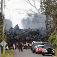 Onlookers gather in front of a fresh lava flow from the Kilauea volcano Saturday in the Leilani Estates near Pahoa, Hawaii. | REUTERS