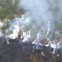 Molten rock flows and burst to the surface, threatening homes in a rural area in this still image from an aerial video taken from a Hawaii Army National Guard a week after the eruption of the Kilauea volcano, in Pahoa, Hawaii, on Thursday. | COURTESY ANDREW JACKSON/ HAWAII DOD/VIA REUTERS