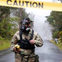 Lieutenant Aaron Hew Lew, of the Hawaii National Guard, measures levels of toxic sulfur dioxide gas near a lava flow in the Leilani Estates subdivision during ongoing eruptions of the Kilauea Volcano, Hawaii, on May 8. | REUTERS