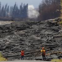 United States Geological Survey personnel monitor and record active lava fissures near what is now the end of Kahukai Street  on Thursday. | HONOLULU STAR-ADVERTISER / VIA AP