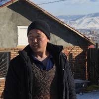 Former herder Chudur Jugdur stands in front of his new house in Ulaanbaatar on Feb. 8. | THOMSON REUTERS FOUNDATION/SHANSHAN CHEN