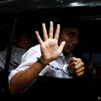 Detained Reuters journalist Kyaw Soe Oo leaves in a police vehicle after a court hearing in Yangon Monday. | REUTERS