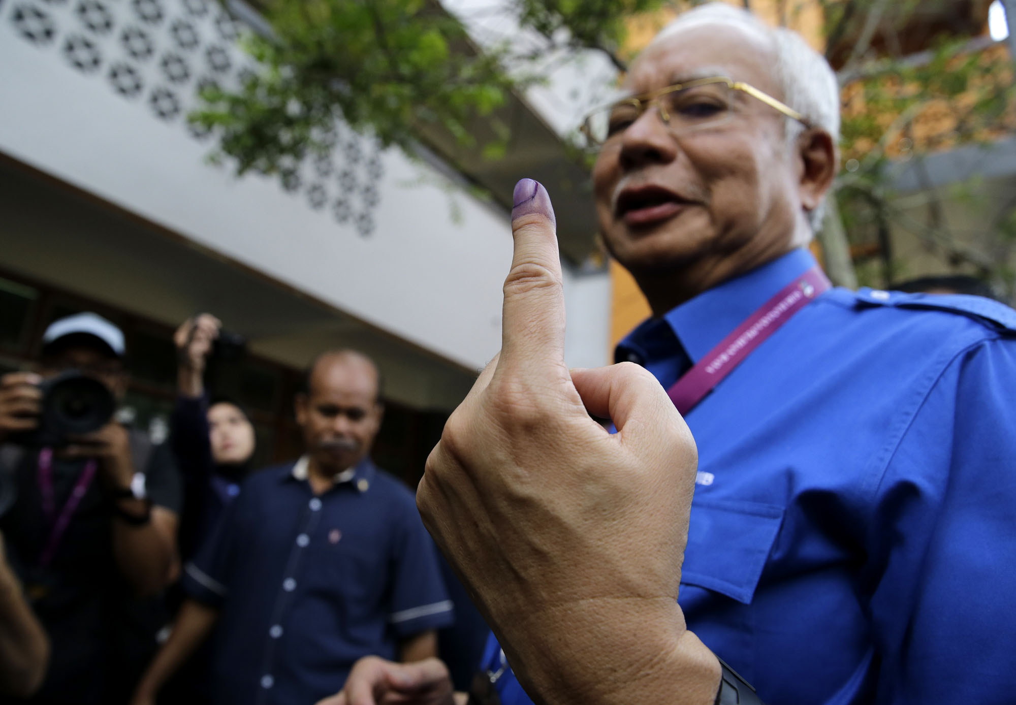 Malaysian Prime Minister Najib Razak shows his finger marked with ink after voting at his hometown in Pekan, Malaysia, on May 9. | AP