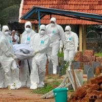 Doctors and relatives wearing protective gear carry the body of a victim who lost his battle against the brain-damaging Nipah virus, during his funeral at a burial ground in Kozhikode, in the southern Indian state of Kerala, India, May 24. | REUTERS