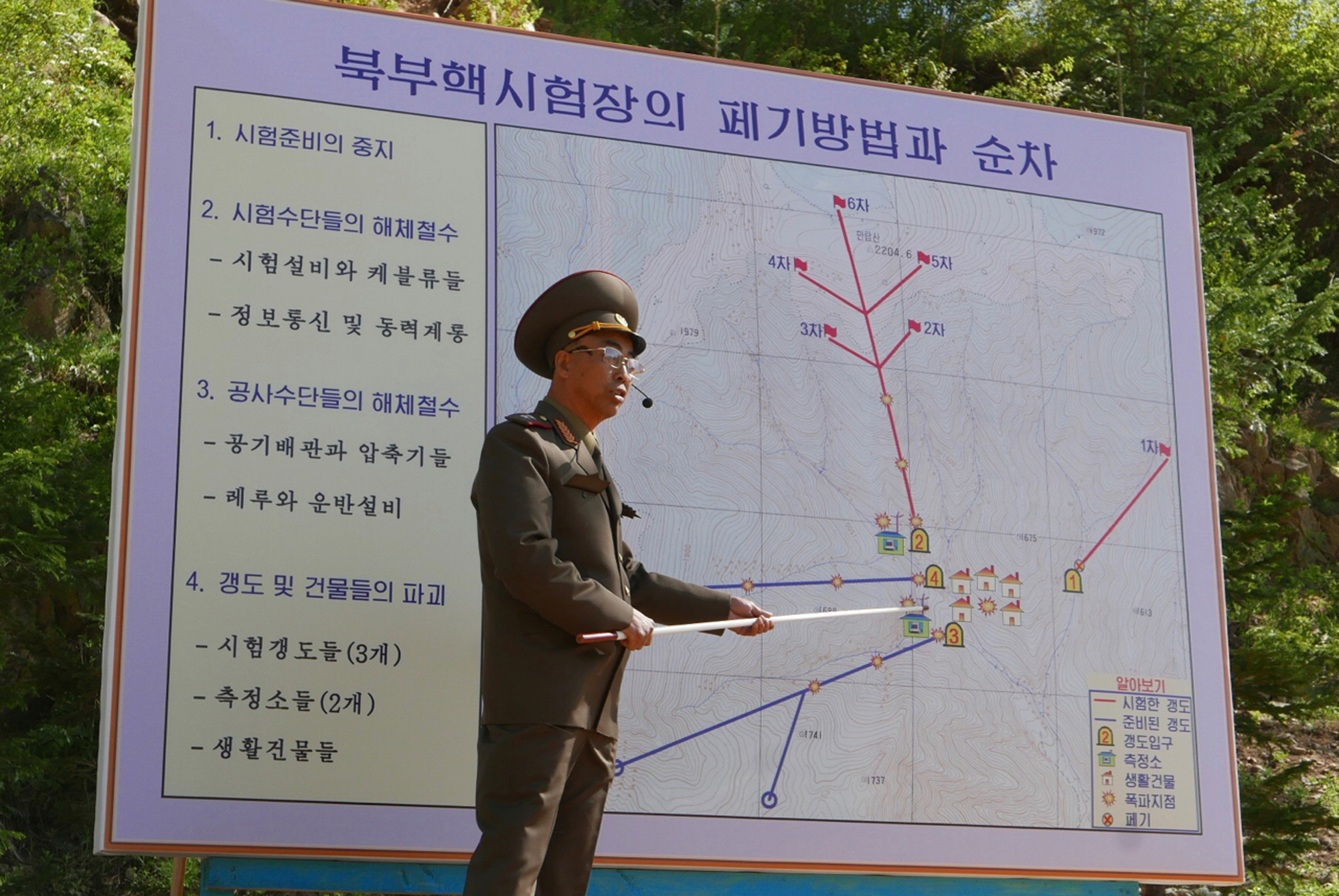 The deputy director of North Korea's Nuclear Weapons Institute, who would not give his name, briefs reporters in Punggye-ri on May 24 about the dismantling of the country's nuclear test site. | AP