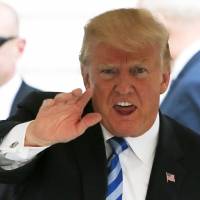 U.S. President Donald Trump waves on the South Lawn of the White House on Friday after returning from addressing the NRA convention in Dallas. | REUTERS